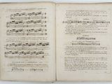 an open book with music notes on it sitting on a table