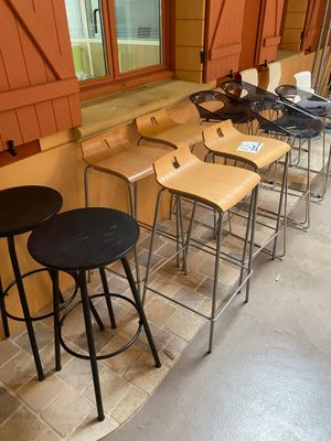 many stools lined up in a row in front of a window