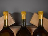 three bottles of wine sitting in a wooden box