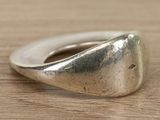 sterling silver ring with a triangular design on a wooden surface