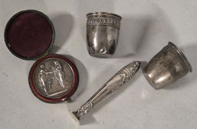 several silver objects are sitting on a white surface next to a red box