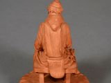 an image of a clay figurine of a man sitting on a bench
