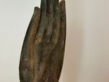 a wooden sculpture of a hand on a stand