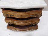a marble top chest of drawers on a white table