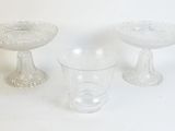 three glass bowls and a glass cup on a table