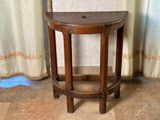 un petit tabouret en bois posé sur un sol carrelé, à côté d'un rideau