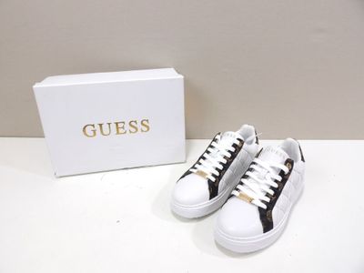 white and black sneakers with gold logo on the side of them