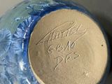 a blue vase with writing on it sitting on a table