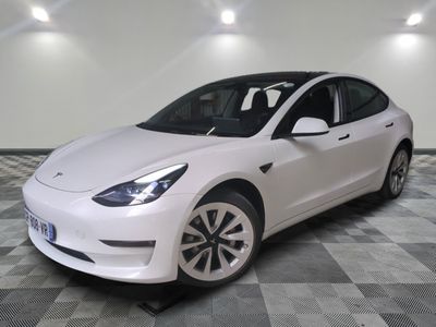 La Tesla Model 3 blanche est garée sur un sol à damier
