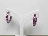 une paire de boucles d'oreilles en améthorate et diamants, présentées sur un socle blanc