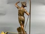 bronze figurine of a boy holding a pole with a lamp on it