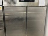 a stainless steel refrigerator in the corner of a kitchen