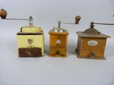 Trois modèles différents de moulins à café sont présentés sur une surface blanche
