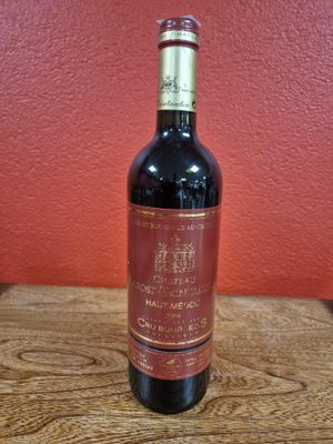 a bottle of red wine sitting on a wooden table