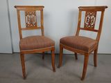 deux chaises en bois avec des assises rembourrées à motifs dans une pièce