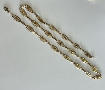 three gold plated spoons and a spoon rest on a white surface