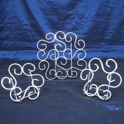 trois sculptures métalliques aux formes tourbillonnantes reposent sur une surface bleue
