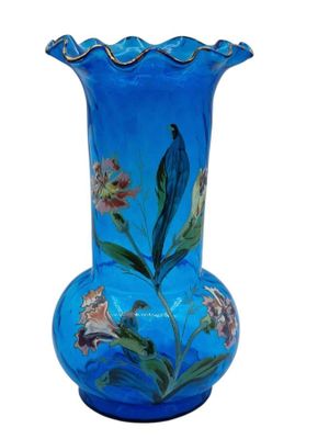 un vase en verre bleu orné d'un motif floral