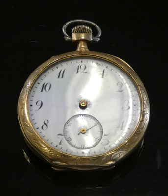 a close up of a pocket watch on a black surface