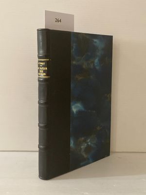 un vieux livre à la couverture noire posé sur une table blanche