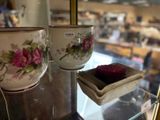two cups and a plate on display in a glass case