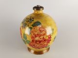 a yellow vase with a red and yellow flower on it