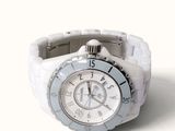 a close up of a white watch on a white surface