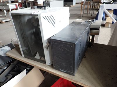two microwaves sitting on a table in a warehouse