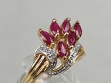 a close up of a gold ring with pink stones on it