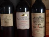 several bottles of red wine are lined up on a shelf