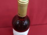 une bouteille de vin posée sur une surface rouge
