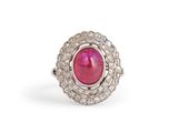 a close up of a ring with a pink stone in it