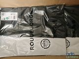 two bags of black and white clothing sitting on top of a cardboard box