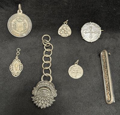 some silver jewelry is laying out on a black surface