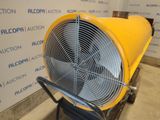 a yellow fan sitting on top of a cart in front of a wall
