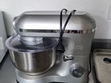 a silver mixer sitting on a kitchen counter next to a pan