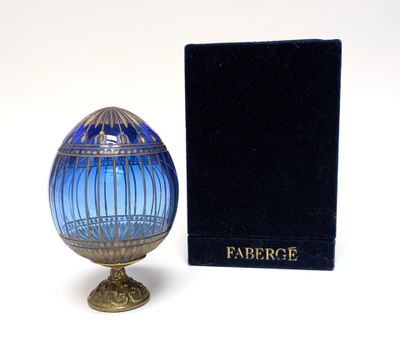 a blue glass egg sitting next to a black box