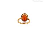 a close up of a gold ring with an orange stone