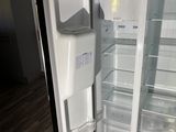 an open refrigerator with its door open on a wooden floor