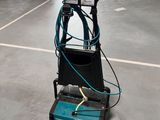 une autolaveuse électrique dans un entrepôt, équipée d'un tuyau