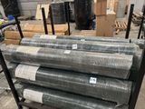 many rolls of metal mesh on a cart in a warehouse