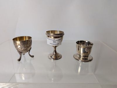 three silver goblets sitting on a glass table