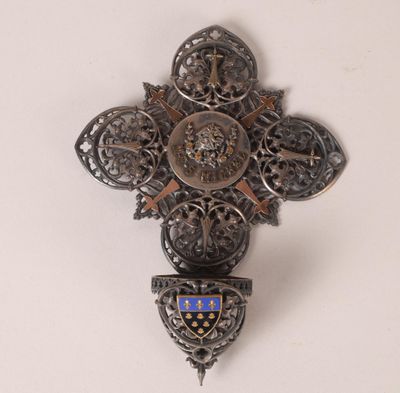 une croix accrochée au mur, sur laquelle figure un blason