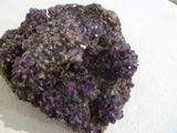 un morceau de roche sur lequel se trouvent des cristaux violets