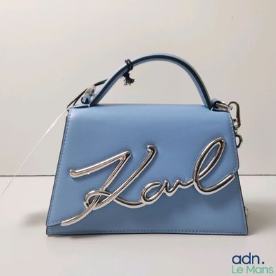 sac à main en cuir bleu sur lequel est inscrit le mot « love »