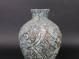 a blue vase with a pattern on it on a black background
