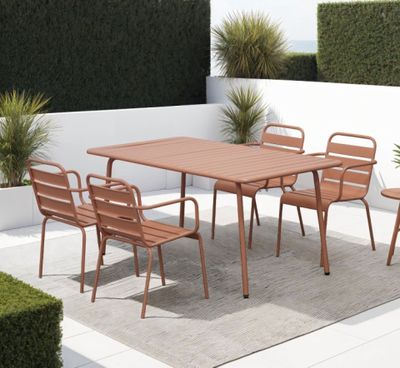 une table et des chaises sur une terrasse recouverte d'un tapis