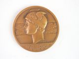 a gold medal with a woman ' s head on it