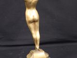 a gold statue of a woman on a marble base