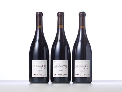 three bottles of wine are lined up on a table